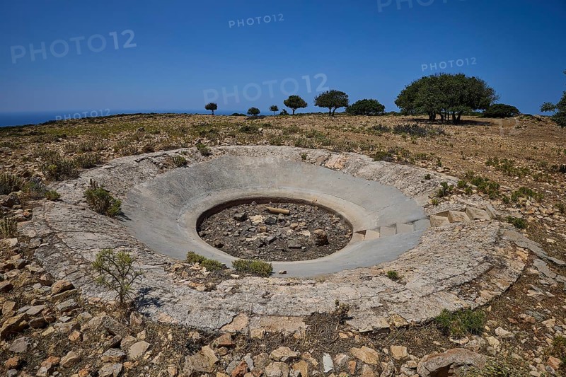 Large concrete crater in an open, rocky landscape under a clear sky, Lost Place, Air Defence Position, Aerophone, Parabolic Acoustic Mirror, Patella Mountain, WW2, west of Lakki, Leros, Dodecanese, Greek Islands, Greece