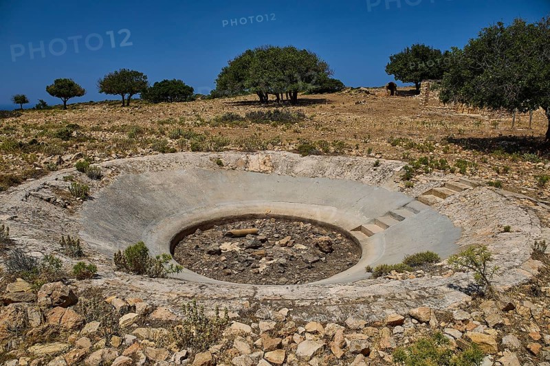 Round crater in a barren landscape with some trees on the horizon, Lost Place, Air Defence Position, Aerophone, Parabolic Acoustic Mirror, Patella Mountain, WW2, west of Lakki, Leros, Dodecanese, Greek Islands, Greece