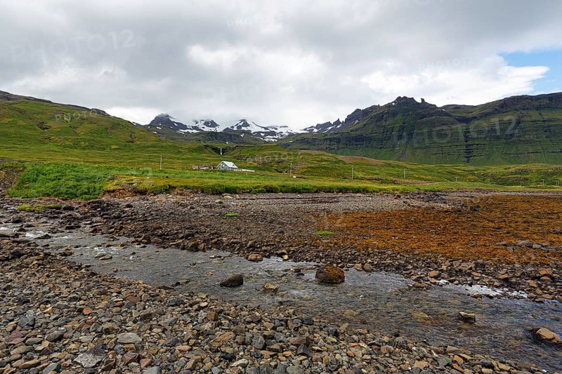 Rocky volcanic landscape near Grundarfjördur, snow-capped mountains on the horizon, Snæfellsnes peninsula, Snaefellsnes, West Iceland, Vesturland, Iceland