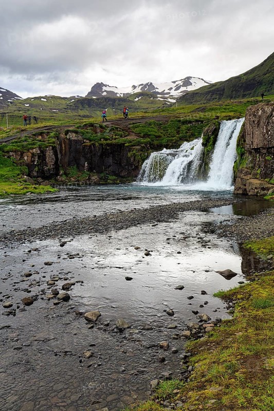 Hikers, tourists at Kirkjufellfoss waterfall, Kirkjufellsa river, Grundarfjördur, Snæfellsnes peninsula, Vesturland, Iceland