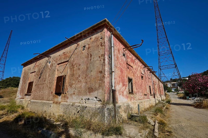 Lost Place, Old building with rusty pipes and electricity tower under clear sky, Radio Station, WW2, Agios Nikolaos Radio, Agia Marina, Leros, Dodecanese, Greek Islands, Greece