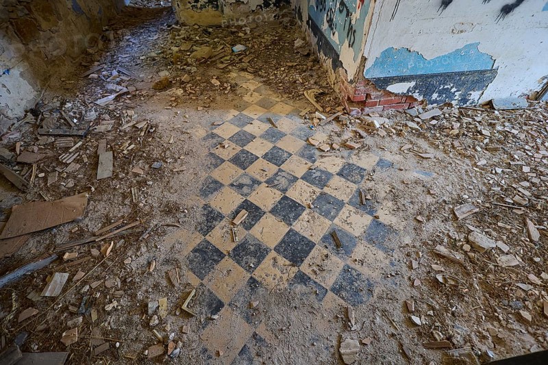 Lost Place, chequered pattern on the floor of a dilapidated room, surrounded by rubble and blue walls, Radio Station, WW2, Agios Nikolaos Radio, Agia Marina, Leros, Dodecanese, Greek Islands, Greece