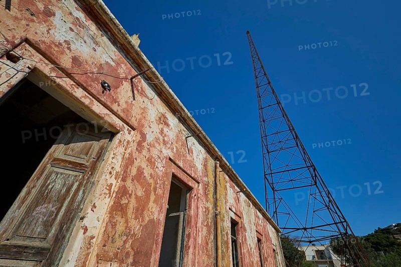 Lost Place, Old building with metal structure in the background, antenna mast, peeling plaster and clear sky view, Radio Station, WW2, Agios Nikolaos Radio, Agia Marina, Leros, Dodecanese, Greek Islands, Greece