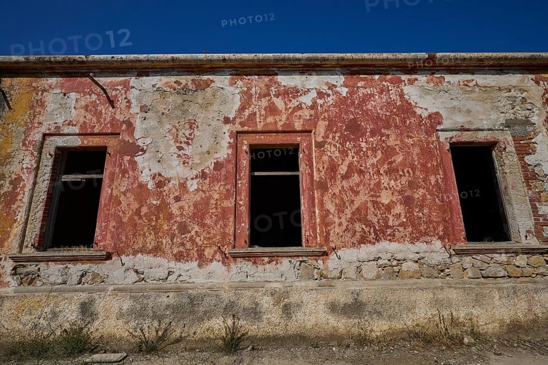 Lost Place, The facade of a dilapidated building with red and white discolouration, Radio Station, WW2, Agios Nikolaos Radio, Agia Marina, Leros, Dodecanese, Greek Islands, Greece