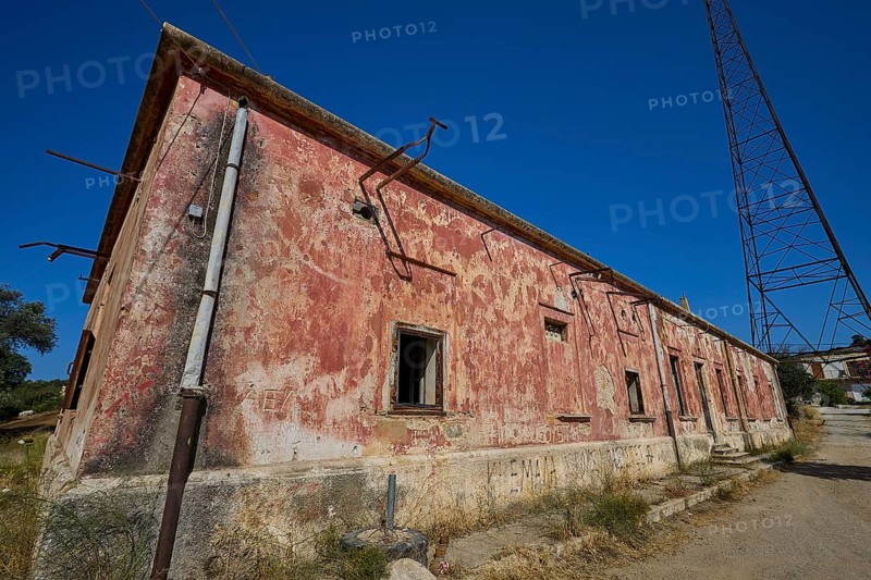 Lost Place, Red, peeling building with electric poles and cables under the open sky, Antenna mast, Radio Station, WW2, Agios Nikolaos Radio, Agia Marina, Leros, Dodecanese, Greek Islands, Greece