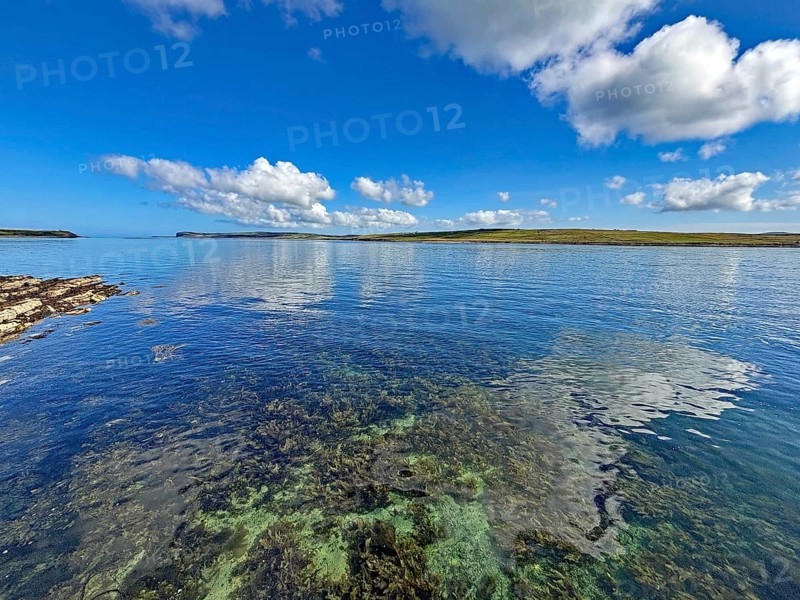 Clear sea with calm atmosphere, blue sky and clouds along the coastline, Hoy, Orkney Islands, Scotland, United Kingdom