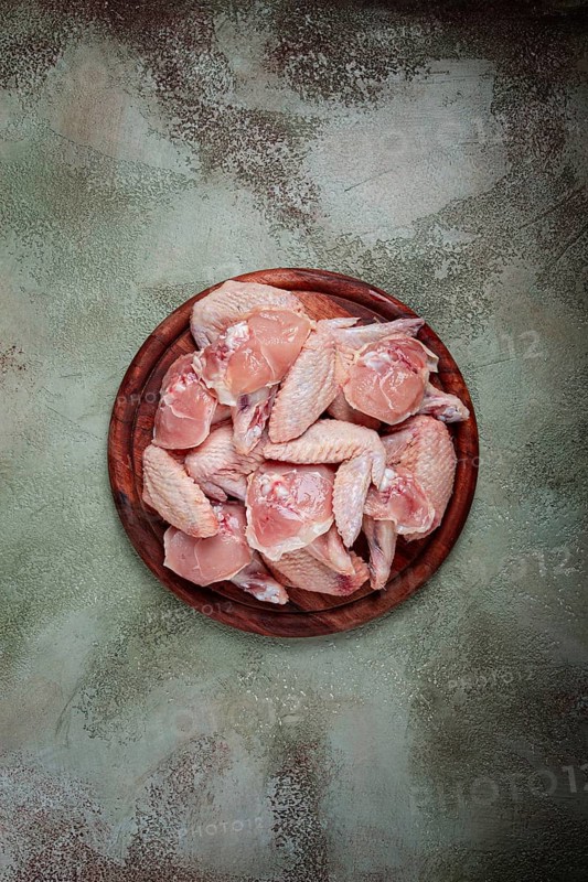 Raw chicken wings, on a wooden board, top view, no people