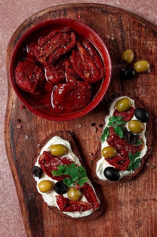 Sandwich with cream cheese, dried tomatoes, olives, breakfast, top view