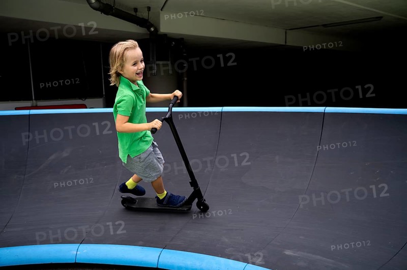 Boy, 6 years, blond, rides scooter, scooter, pump track, laughs, joy, Stuttgart, Baden-Württemberg, Germany