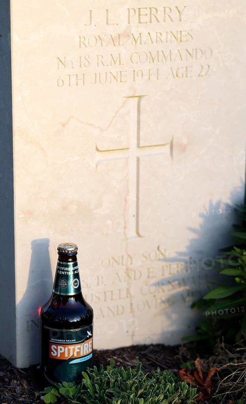 Bottle of Spitfire Kentish Ale, beer, at a gravestone, war graves, military graves, British and German military cemetery, Cimetière militaire britannique, D-Day, Operation Overlord, evening light, Bayeux, Normandy, Calvados, France