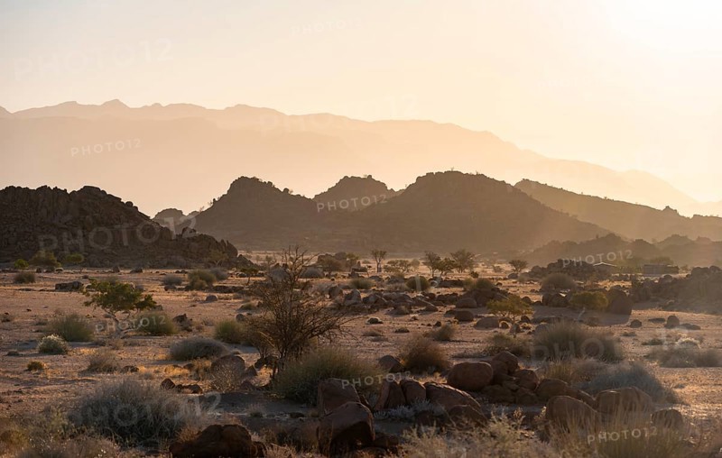 Barren landscape with hills of stacked rocks, desert landscape in the evening light at sunset, Brandberg, Erongo, Damaraland, Namibia