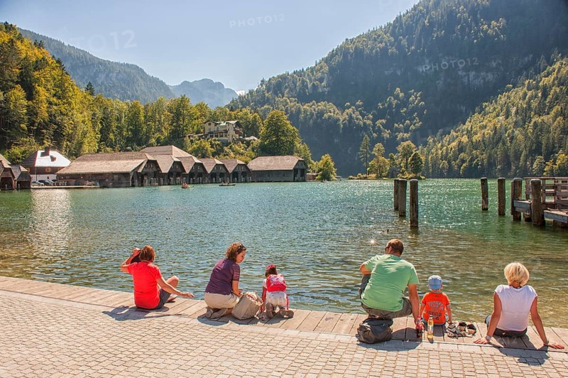 Tourists camp at Königssee, mountain lake in the municipality of Schönau am Königssee, district of Berchtesgadener Land. It is nestled between the steep mountain slopes of the Watzmann and Hagengebirge mountains and has a fjord-like character. It is one of the cleanest lakes in Germany. Navigation since the 18th century. Upper Bavaria, Bavaria