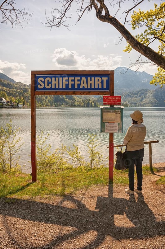 Lake Kochel, tourist reads the navigation map, Kochel, Upper Bavaria, Bavaria