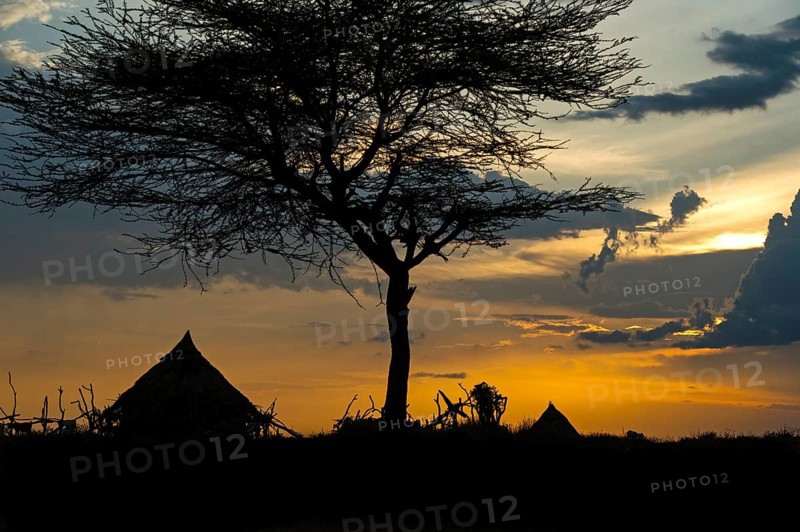Silhouette of conical huts of the Hamer ethnic group against a dramatic sunset sky, Southern Omo Valley, Ethiopia