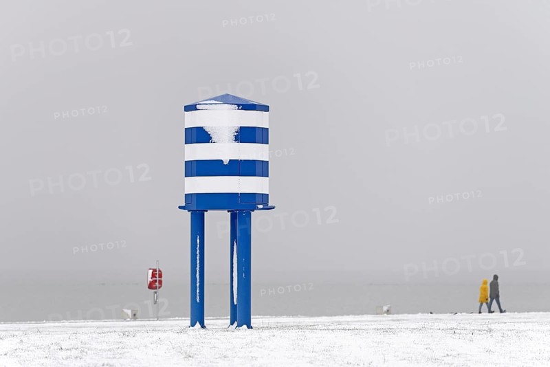 Winter day, onset of winter, snow on the North Sea coast, people walking on the beach promenade of Norddeich, Lower Saxony, Germany