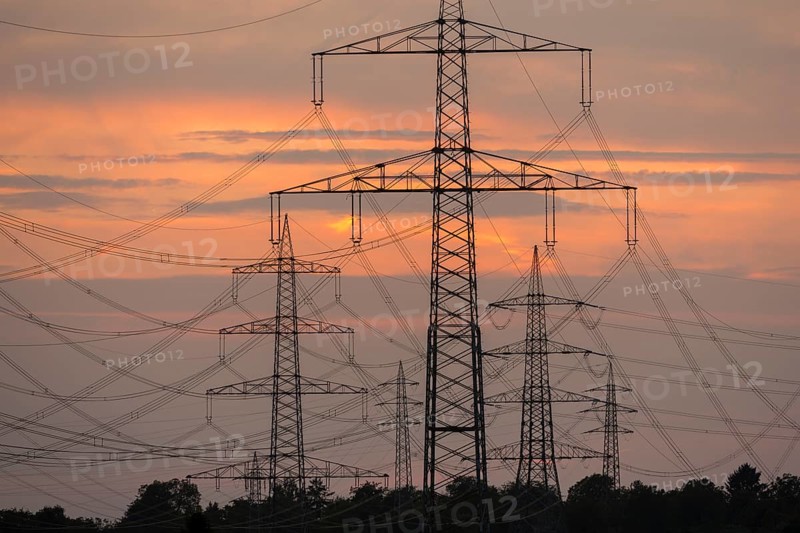 Close-up of electricity pylons against a brilliant orange evening sky, Waiblingen, Baden-Württemberg, Germany