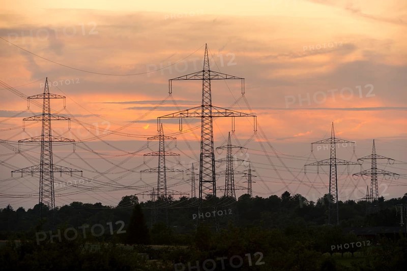 Electricity pylons in front of a pastel-coloured sunset sky with clouds, Waiblingen, Baden-Württemberg, Germany
