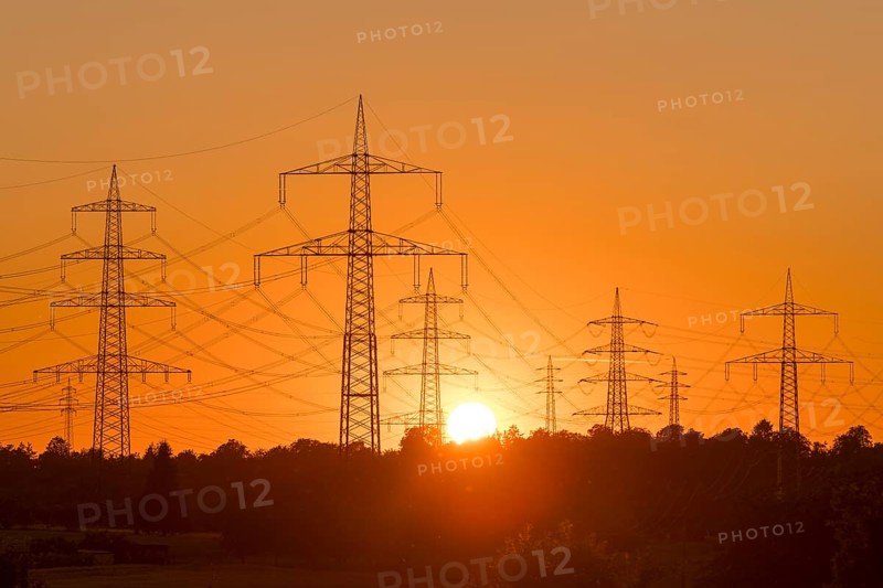 Electricity pylons in front of a glowing sunset on the horizon, Waiblingen, Baden-Württemberg, Germany