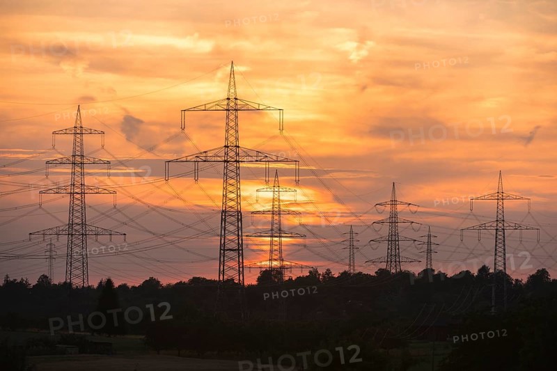 Sunset with electricity pylons and orange sky in a rural setting, Waiblingen, Baden-Württemberg, Germany