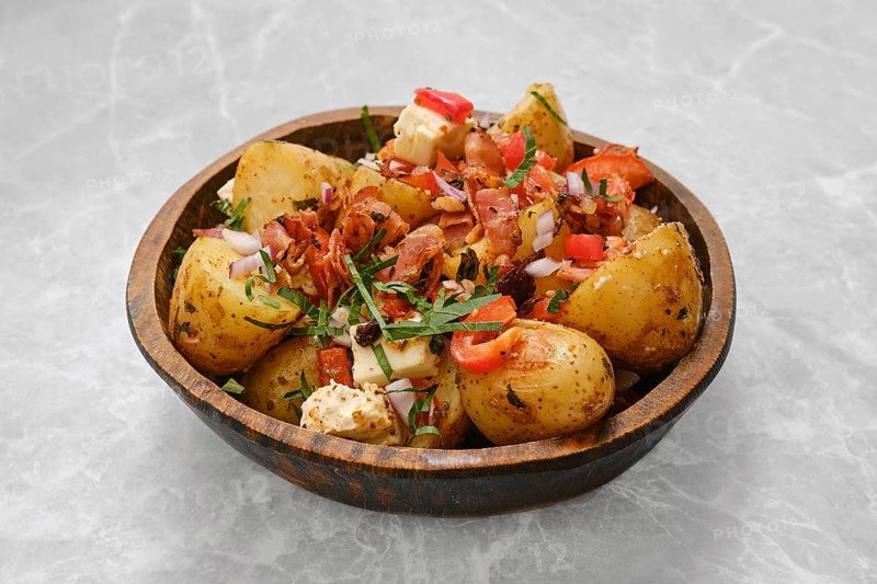 Perfectly cooked baby potatoes are seasoned with herbs and topped with crispy bacon, fresh tomatoes, onions, and a sprinkle of parsley. This savory dish is ideal for gatherings or casual meals