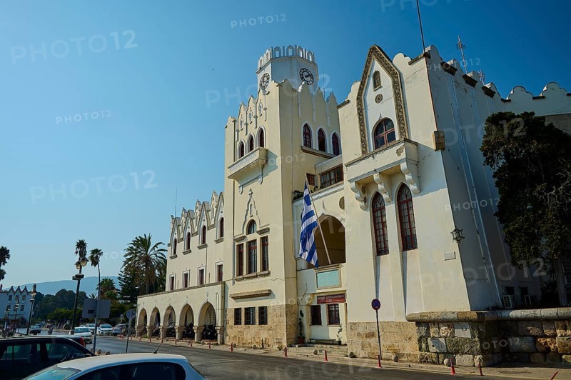 Palace of Justice, Colonial building, A street with a historic building, clock tower and palm trees under a bright blue sky, Kos Town, Kos, Dodecanese, Greek Islands, Greece