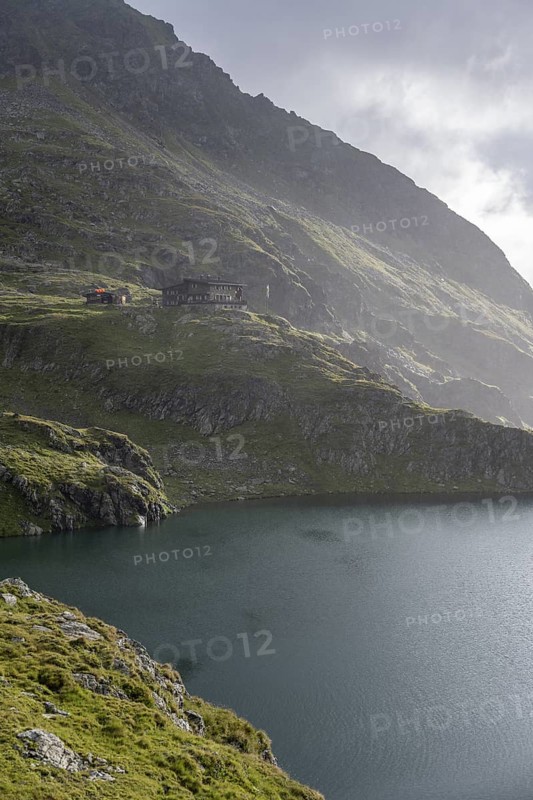 Wangenitzseehütte and mountain lake Wangenitzsee, cloudy mountain peaks in the morning, Schober group, Hohe Tauern National Park, Carinthia, Austria