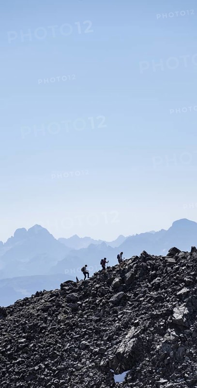 Hikers against the light on a ridge, Stubai Alps, South Tyrol, Italy