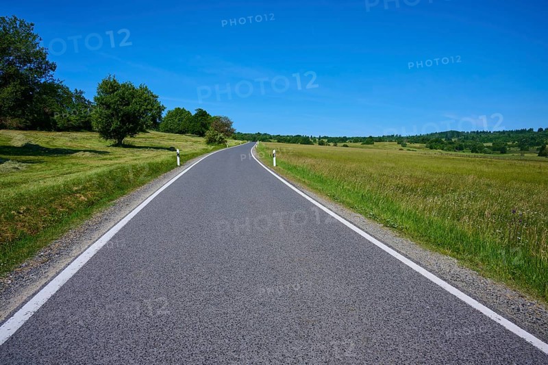 Rural road leads through green meadows under a clear blue sky, summer, Franzosenweg, Lange Rhön, Oberelsbach, Rhön, Bavaria, Germany