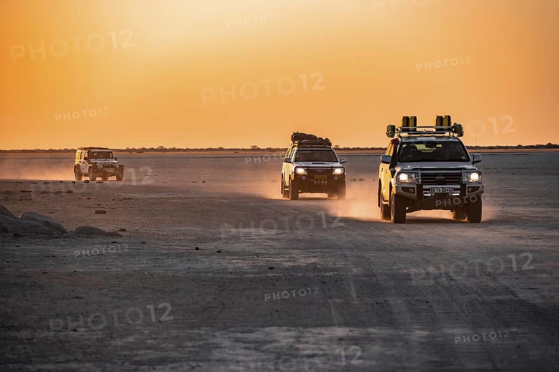 Tourists explore dry landscape by off-road car, Kubu Island (Lekubu), Sowa Pan, Makgadikgadi salt pans, Botswana