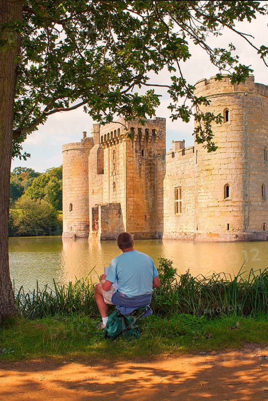 Man draws Bodiam Castle, located in East Sussex near the River Rother. It has long been one of England's most popular and best-known castles. England, UK