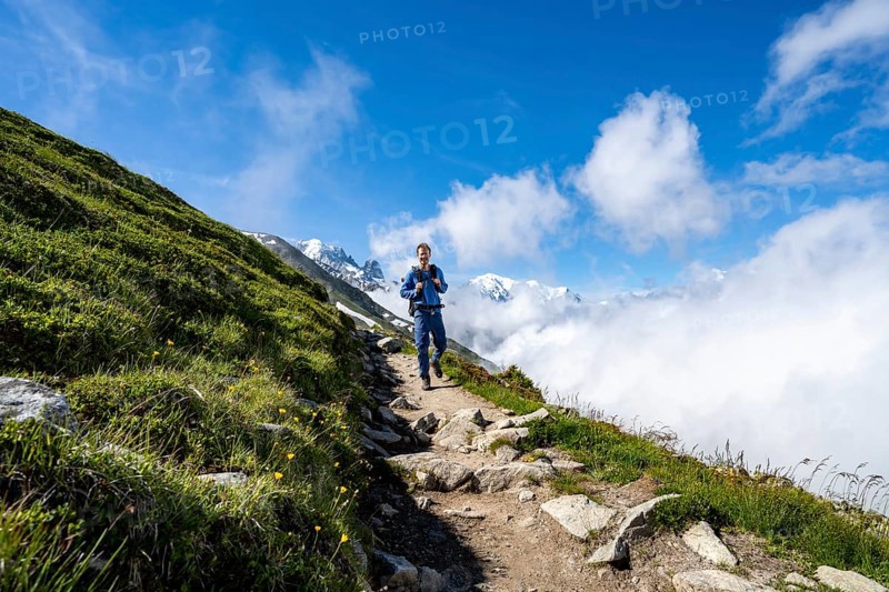 Mountaineer on a hiking trail, inversion weather situation with clouds in the valley, Chamonix, Haute-Savoie, France