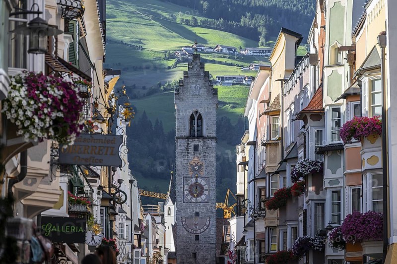 Old town, colourful houses in the main street, Zwölferturm tower at the back, Sterzing, South Tyrol, Italy
