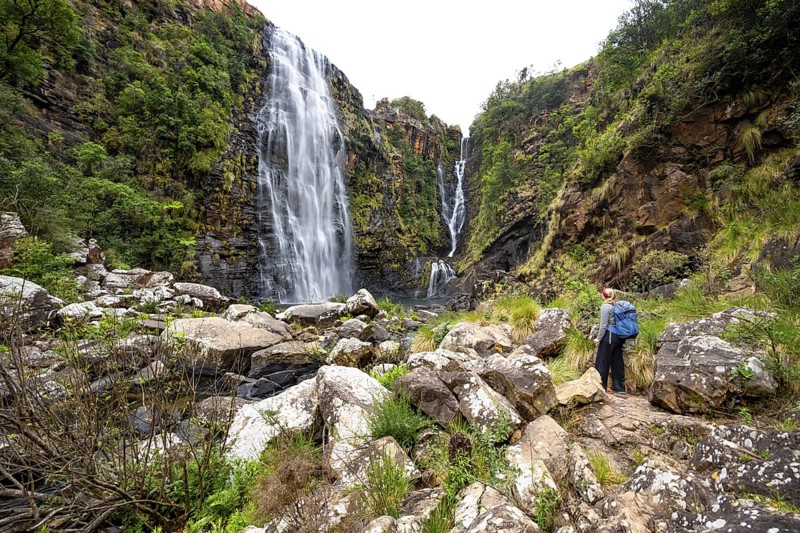 Young woman standing in front of a waterfall, Lisbon Falls, long exposure, near Graskop, Mpumalanga, South Africa