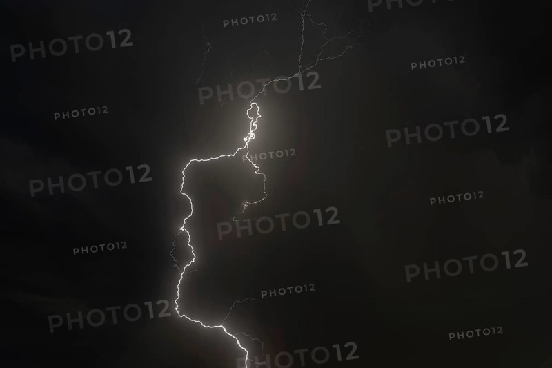 Dark clouds gather as lightning strikes light up the night. The intense storm brings thunder and rain. Bas rhin, Alsace, grand est, France