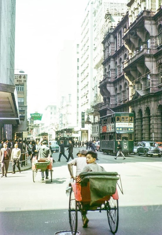 Human rickshaws and green double-decker trolleybus trams, Hong Kong, Asia 1964