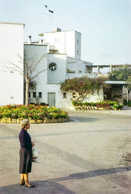 European woman standing next to Royal Hong Kong Yacht Club, Kellet Island, Causeway Bay, Hong Kong, Asia 1964