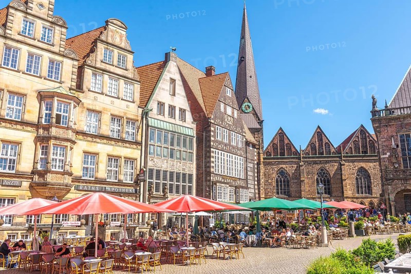 Historic row of buildings with bay windows, gabled houses, pointed tower and nave of Our Lady's Church, pointed gables, numerous tourists, market square with greenery, Old Town, Hanseatic City of Bremen, Germany