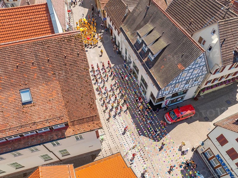Street photographed from above during a parade. People in colourful costumes, old roofs and buildings, 950 years Calw, parade Calw, Black Forest, Germany