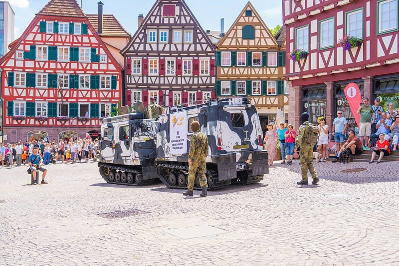 Armoured vehicles stand on a town square with half-timbered buildings and soldiers in camouflage, 950 years of Calw, Calw parade, Black Forest, Germany