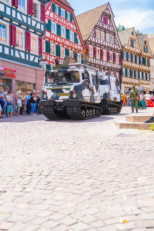 Military vehicles in a parade through a cobbled street with half-timbered houses, 950 years of Calw, Calw parade, Black Forest, Germany