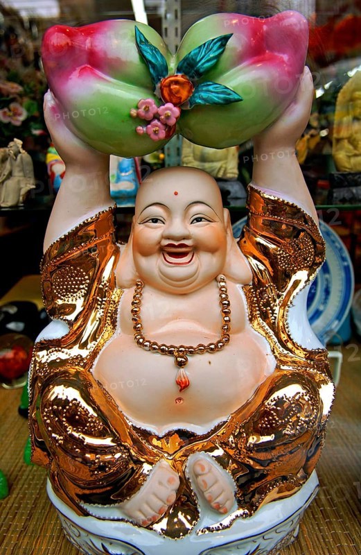 Buddah figure in a shop window, China Town, New York City, USA