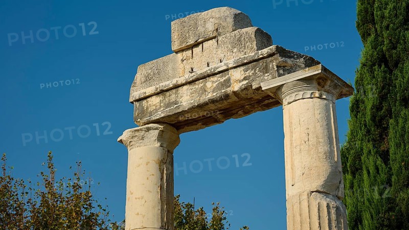 Ancient stone columns against a blue sky, surrounded by trees, Ancient Agora, Kos Town, Kos, Dodecanese, Greek Islands, Greece