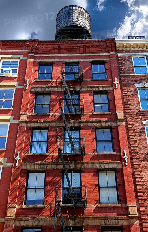 Residential building with fire escapes and wooden water tank on the roof, Downtown NY, New York City, USA