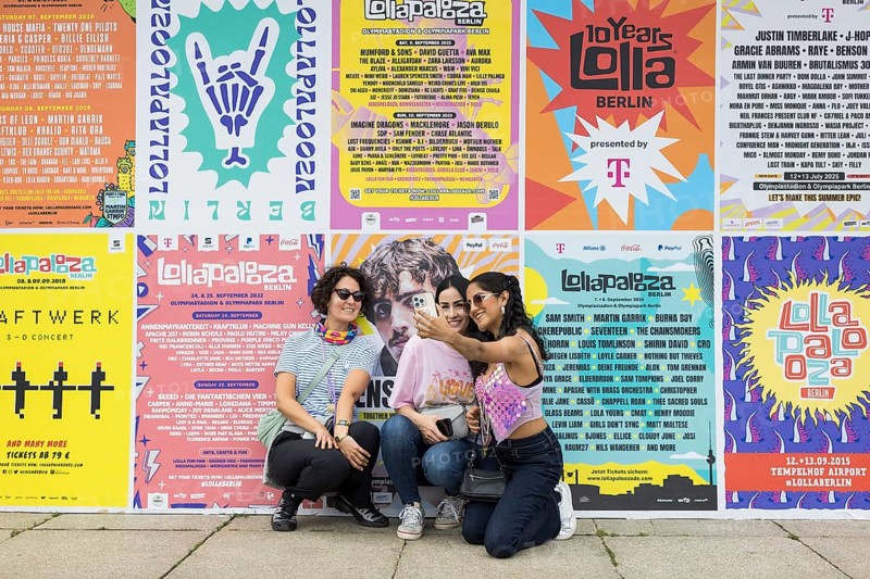 Festival visitors taking photos of themselves in front of Lollapalooza Festival posters from previous years at the Lollapalooza Festival in the Olympic Stadium and on the Maifeld, Berlin, 13.07.2025