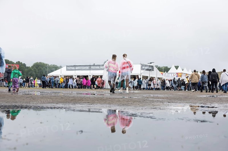 Festival-goers reflected in a puddle at the Lollapalooza Festival in the Olympic Stadium and on the Maifeld, Berlin, 12 July 2025