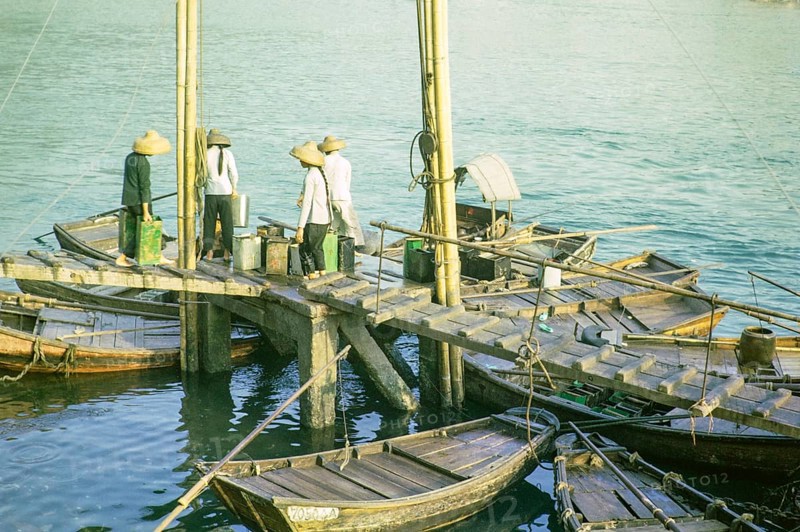 Boat dwellers with cans of water on jetty in the harbour at Aberdeen, Hong Kong, Asia 1964