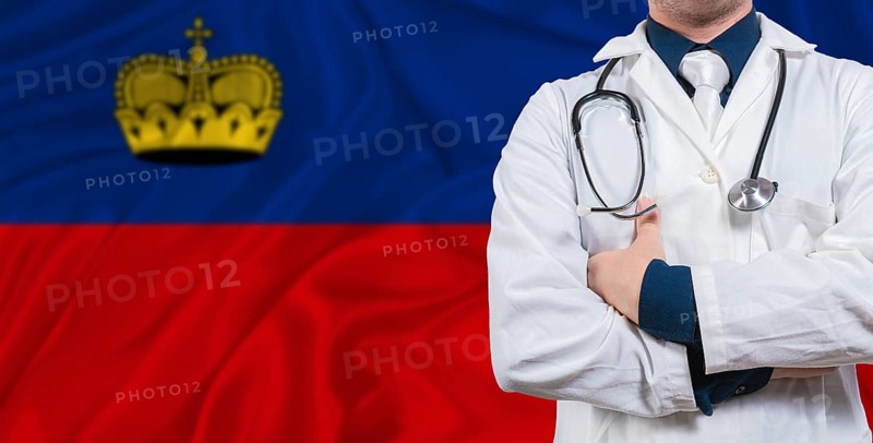 Male doctor with stethoscope on Liechtenstein flag. Doctor holding stethoscope on Liechtenstein flag