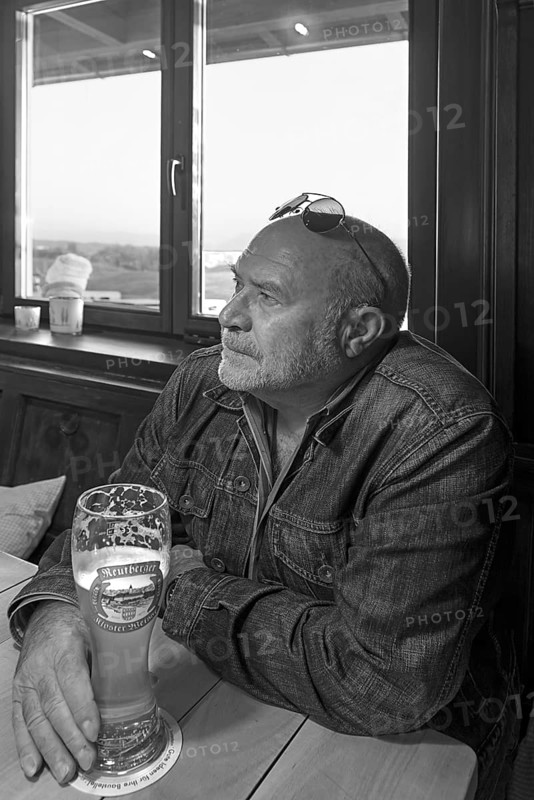 Elderly gentleman with sunglasses and wheat beer in a pub, black and white, Bavaria, Germany