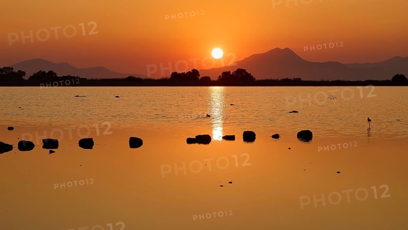 Tranquil landscape with sunset over a lake and distant mountains, salt lake, Tigaki, nature reserve, hydro biotope, Kos, Dodecanese, Greek Islands, Greece