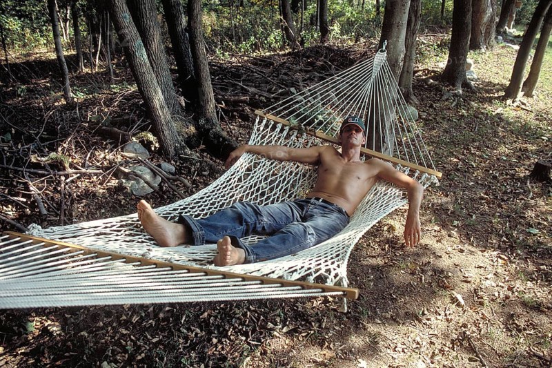 Young man with sunglasses and cap sleeping in a hammock, New Jersey, USA